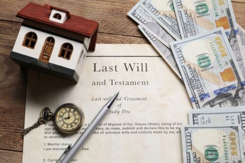 Last Will and Testament, pocket watch, dollar bills, house model and pen on wooden table. Concept for blog discussing when to update your will.