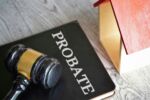 Toy house, gavel and book titled PROBATE. Visual concept for a blog discussing common pitfalls in probate administration.