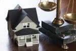 House and Scales of Justice on wood table. Concept bankruptcy exemption statutes
